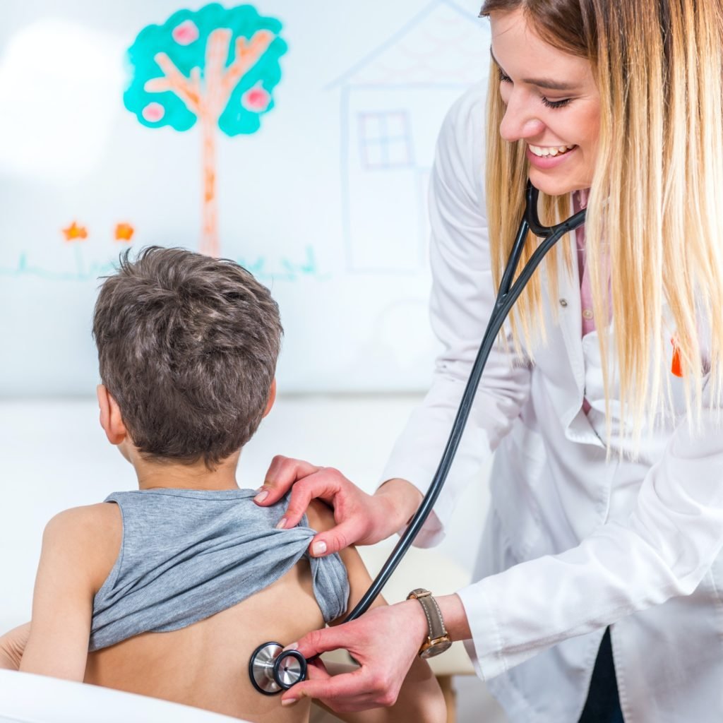 Pediatrician examining boy with stethoscope