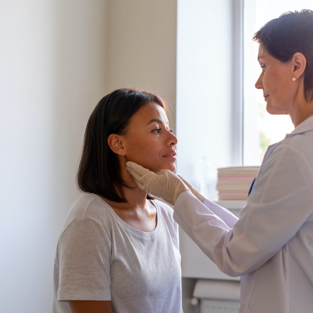 Laryngist examing throat of female patient visiting doctor in hospital